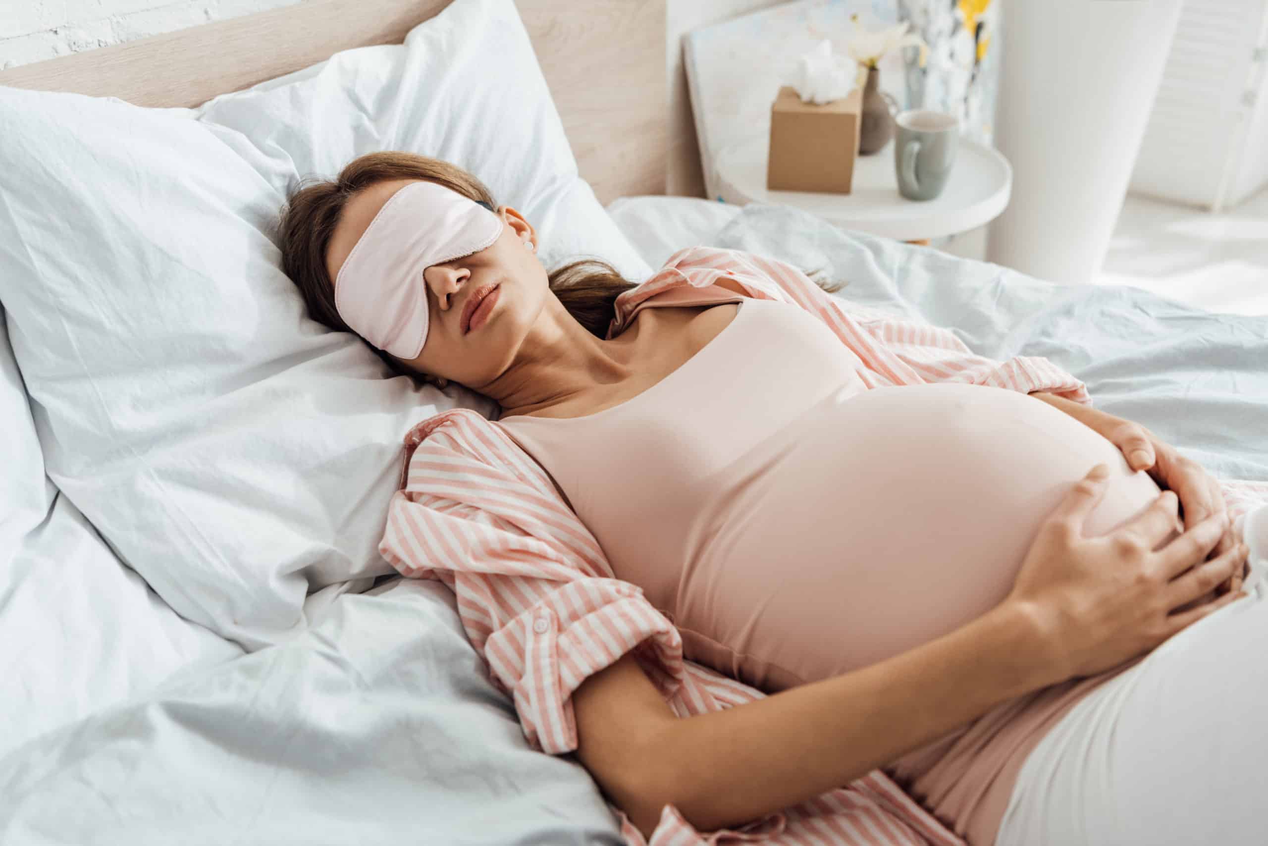 sleeping pregnant woman with a sleep mask on
