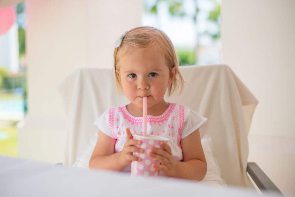 Toddler drinking from a straw sippy cup