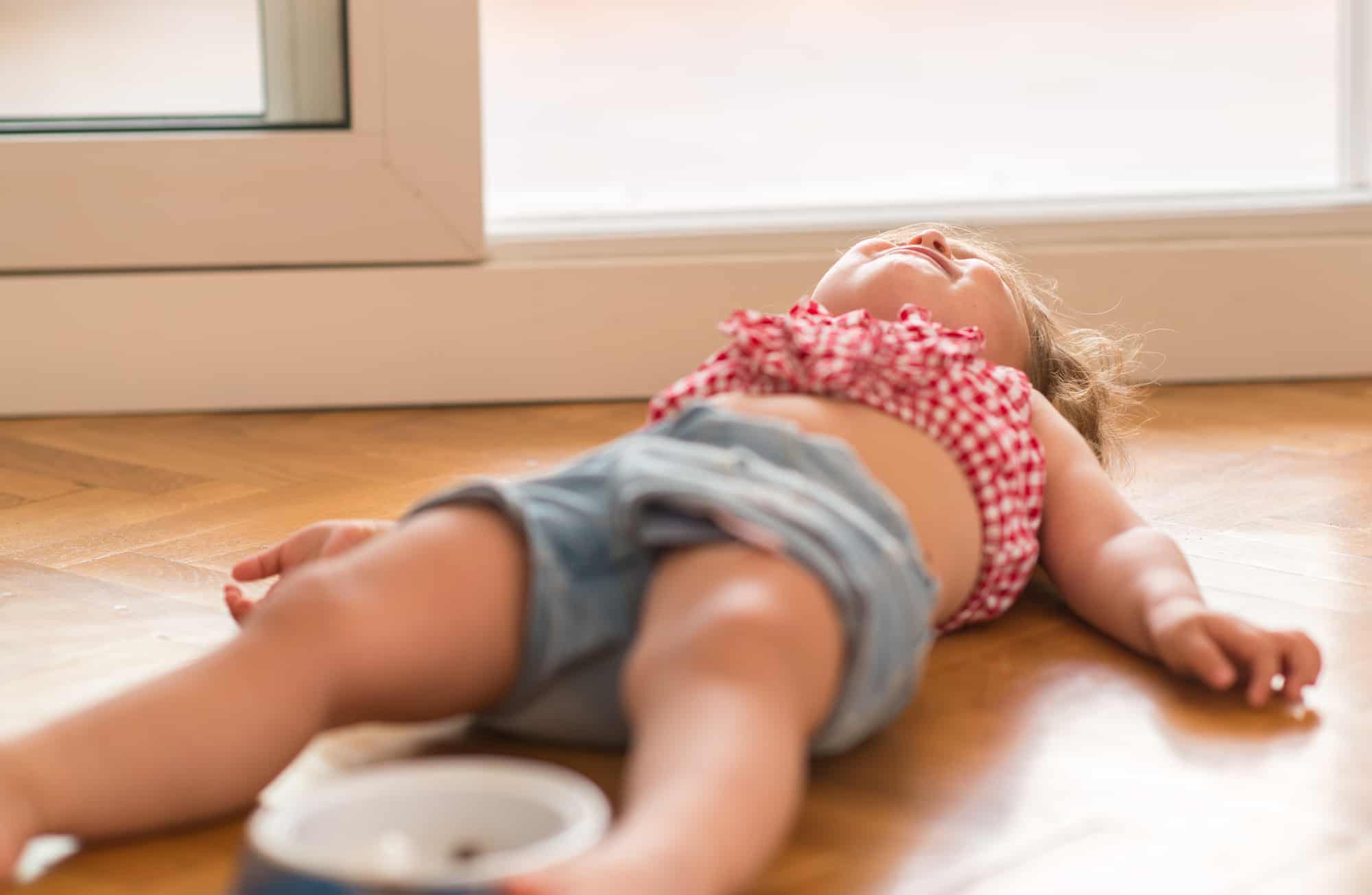 Toddler lying on the ground having a tantrum