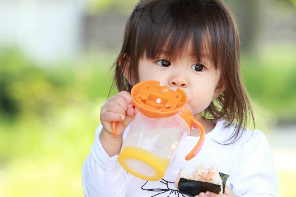 Toddler drinking from a straw cup