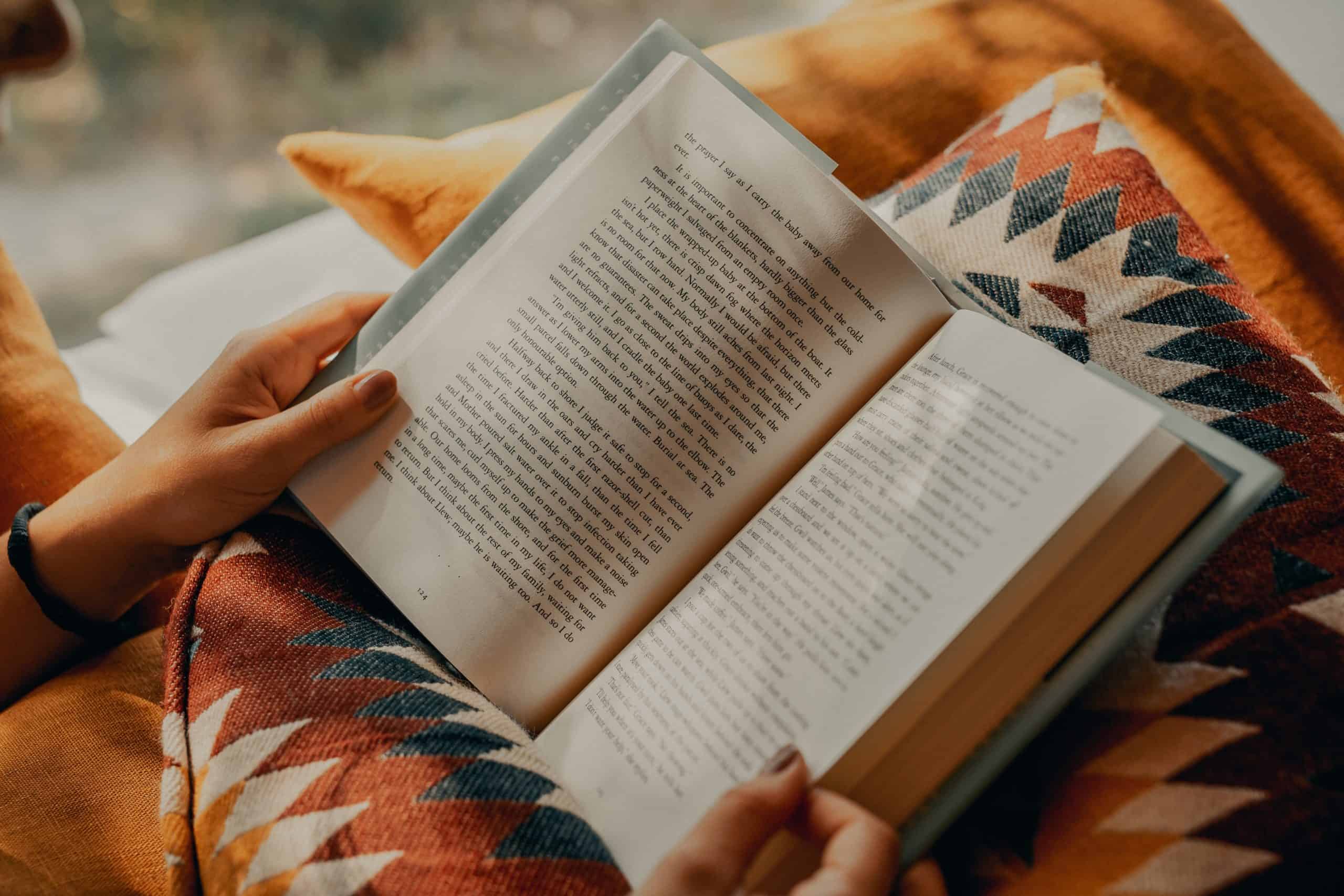 Person holding a book open and reading